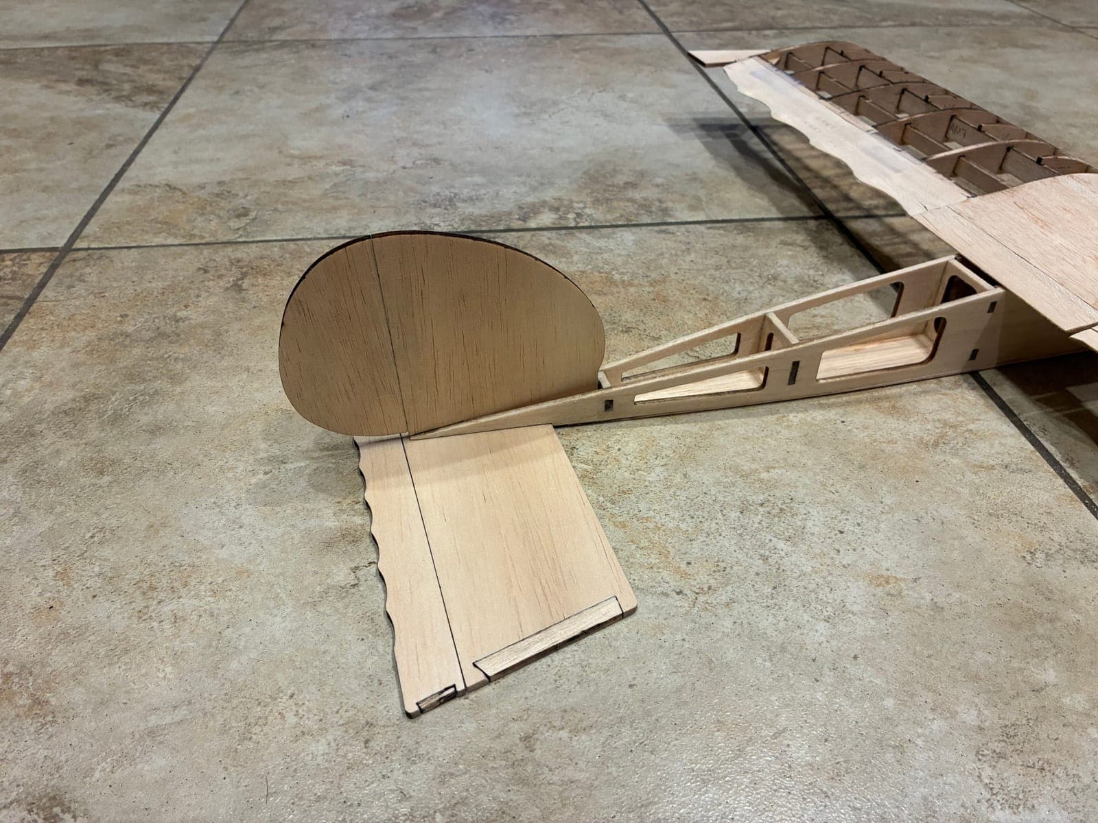 Close-up of tail group: oval fin, stabilizer, and truss tail boom with lightening holes