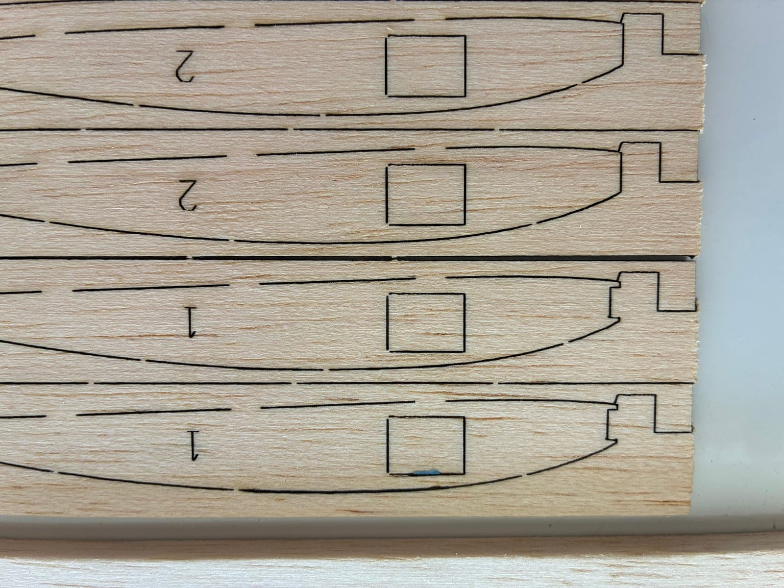 Close-up of laser-cut rib ends showing spar notches, retention tabs, and lightening holes