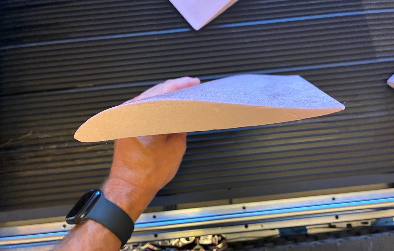 Single foam wing core held up edge-on, showing a clean airfoil profile and sharp trailing edge