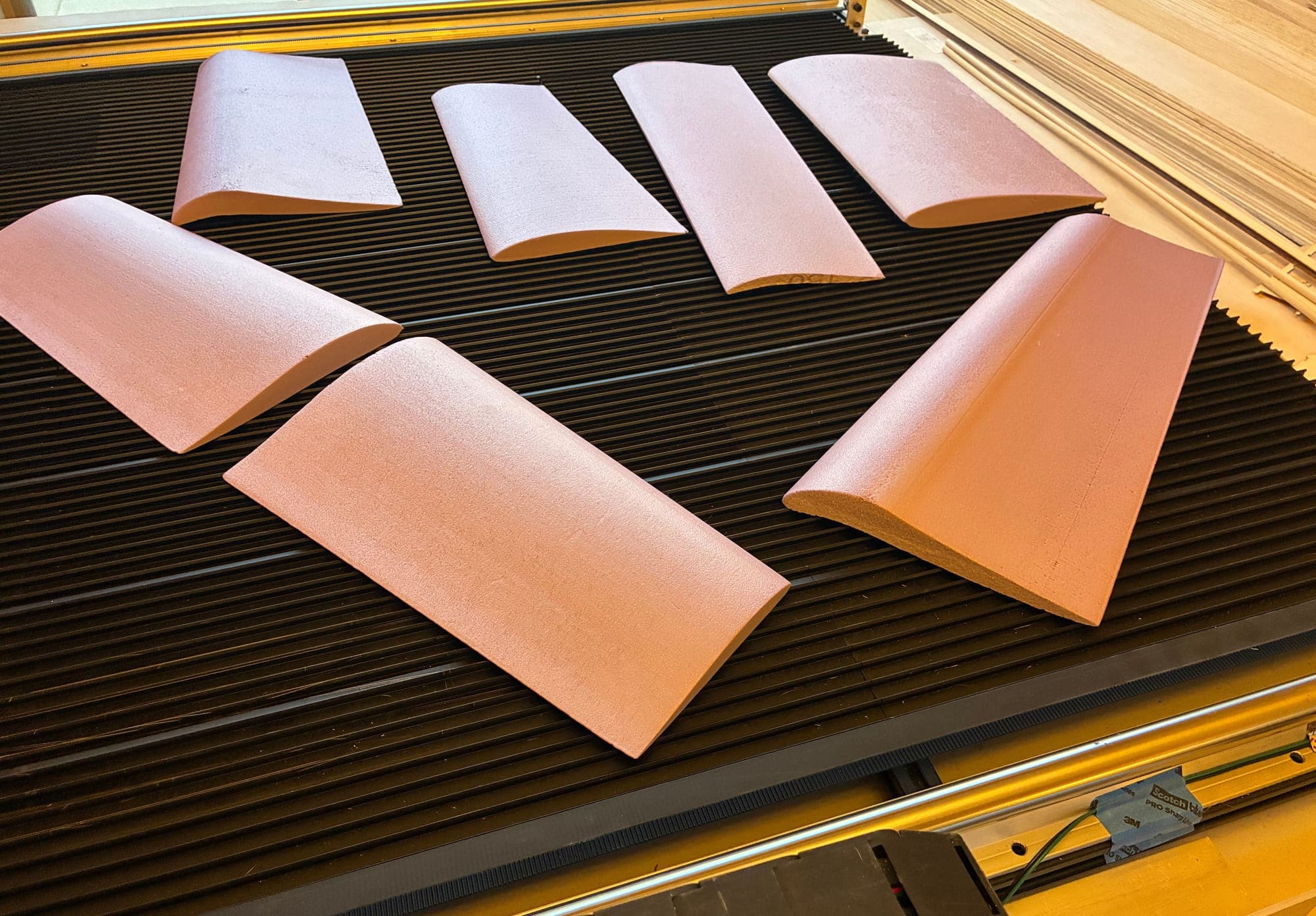 Seven CNC hot-wire-cut pink foam wing cores with clean airfoil profiles