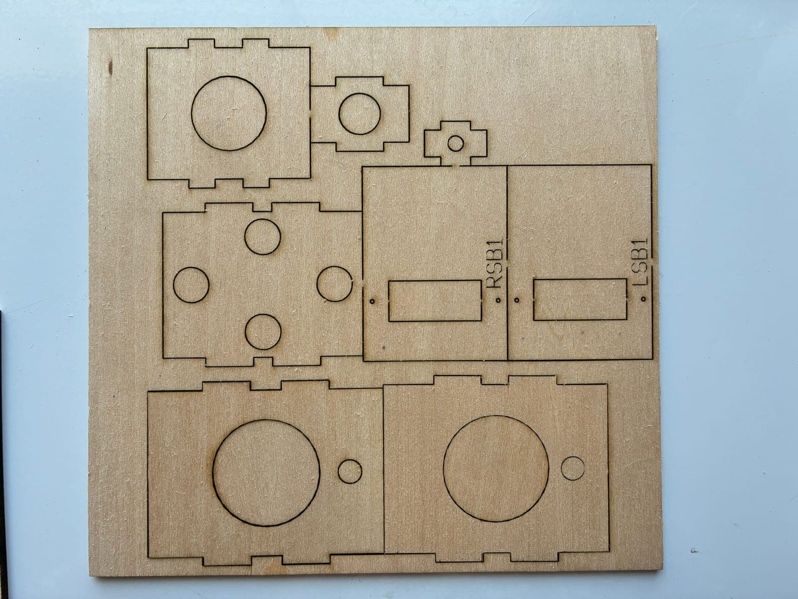 Plywood sheet with laser-cut firewall and formers, engraved part IDs