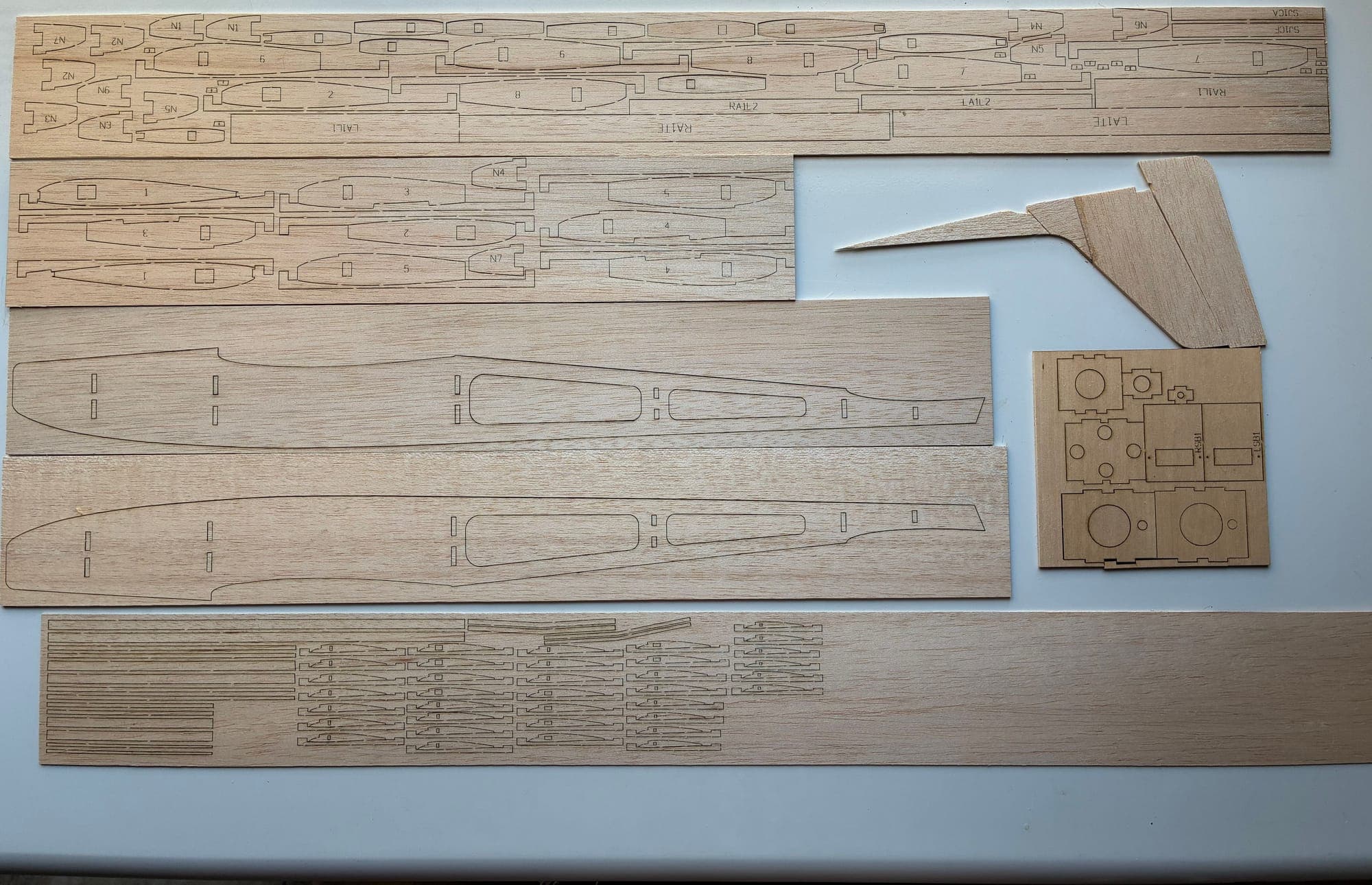 Complete laser-cut kit: nested balsa sheets, plywood formers, and finished tail parts