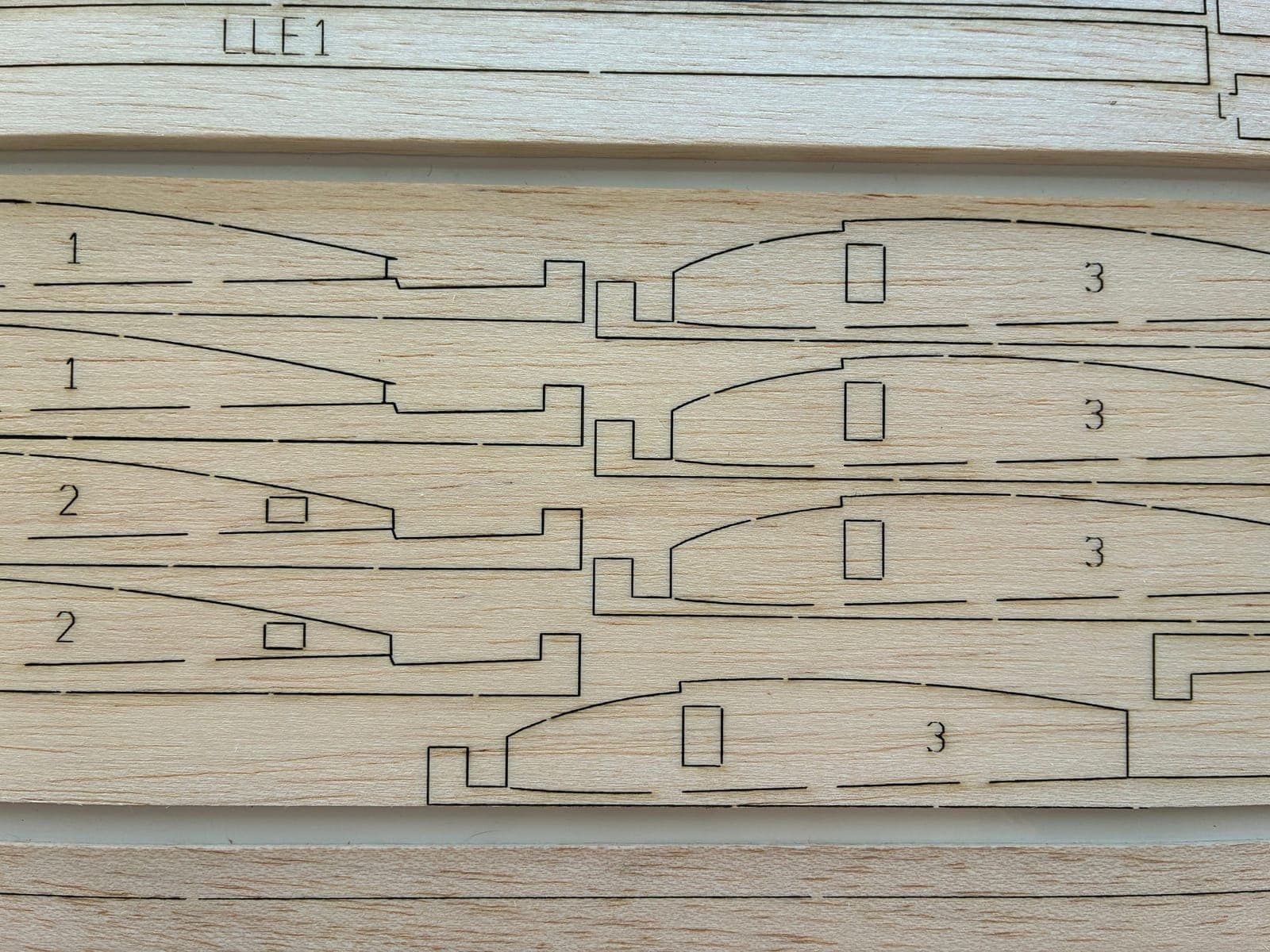 Close-up of numbered ribs nested nose-to-tail on a balsa sheet