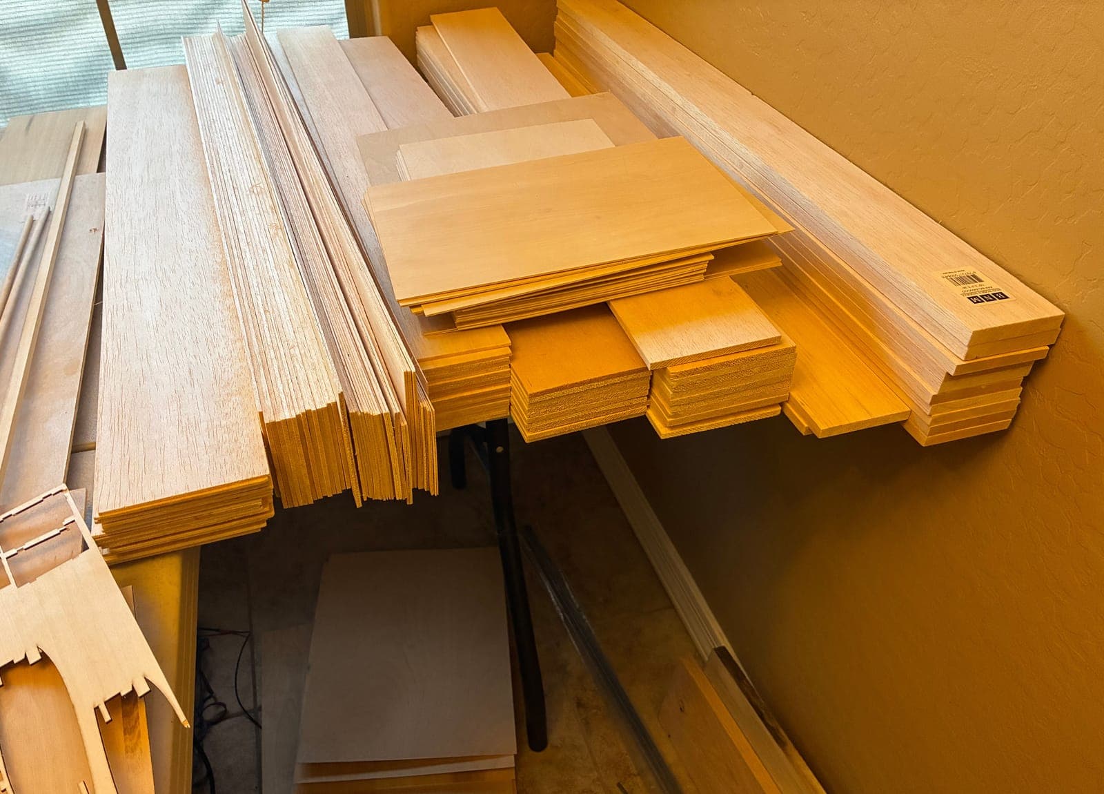 Racks of balsa, light plywood, and basswood sheet and strip stock in the shop